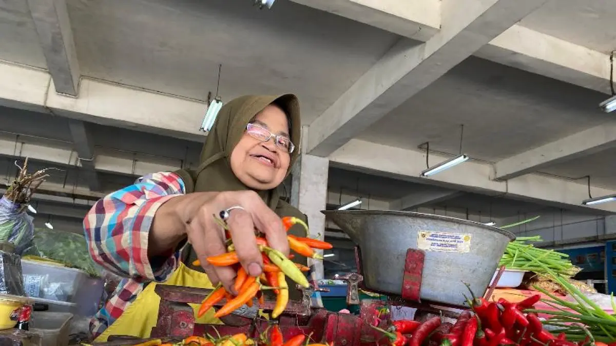 PEDAS: Salah seorang pedagang di Pasar Setonobetek Kota Kediri melayani pembeli cabai rawit di lapaknya. Harga cabai rawit terus naik hari ke hari. (Hilda Nurmala Risani/JPRK)