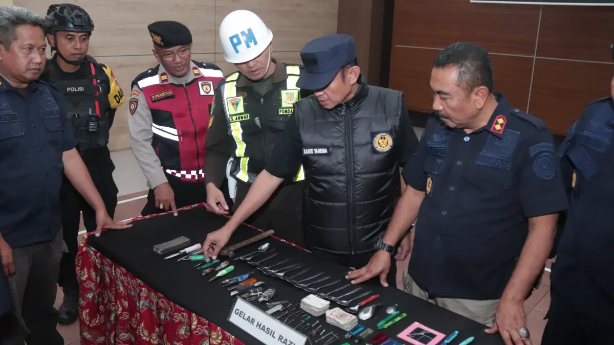  RAZIA : Petugas gabungan melihat barang temuan hasil razia gabungan di Lapas Kelas II A Kediri kemarin (29/5) malam. Ada sajam rakitan hingga kartu remi. (Hilda/JPRK)