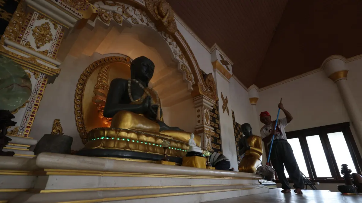 JELANG WAISAK: Petugas vihara membersihkan area di depan patung Buddha Bodhisatwa. Pembersihan dilakukan menjelang jatuhnya perayaan Waisak pada hari ini dan dimulai pukul 15.44 WIB. (Foto: Wahyu Adji)