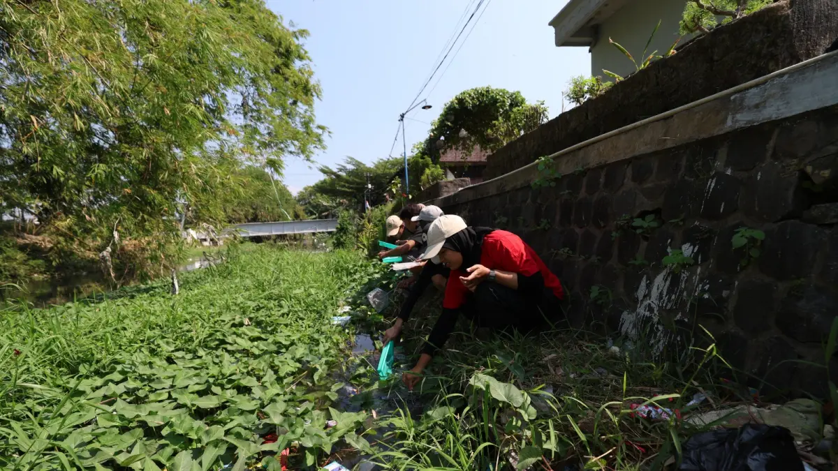 PENUH TUMBUHAN AIR: Tim ekspedisi sungai saat mengamati dan menguji kualitas sungai dengan metode biotilik di aliran Sungai Parung, di Kelurahan Kampungdalem.(Foto: Wahyu Adji)