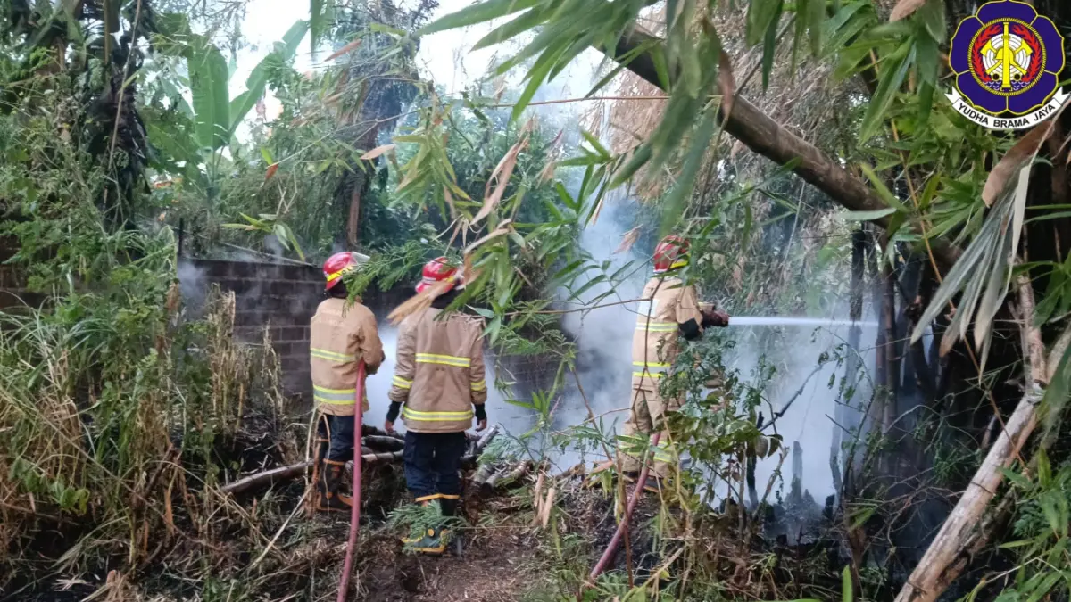 Petugas damkar berusaha memadamkan api yang membakar rumpun bambu di Ngebrak, Kabupaten Kediri Minggu (14/6). (foto damkar kabupaten kediri)