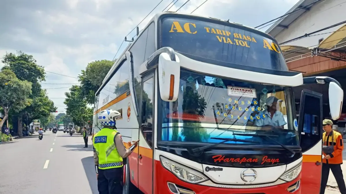 Ilustrasi polisi memberikan teguran kepada pengemudi bus yang terbukti melanggar lalu lintas. (Hilda/JPRK)