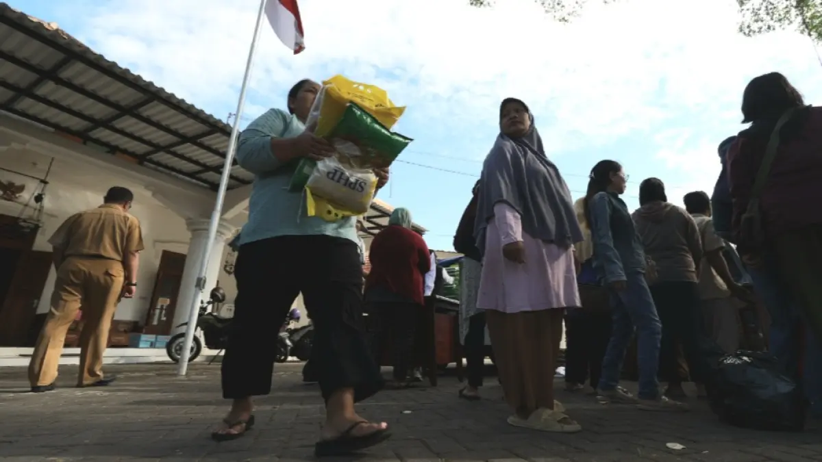 Warga membawa beras SPHP yang dibeli di pasar murah (FOTO: Wahyu Adji)