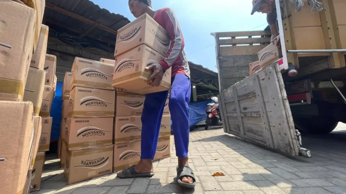 Pekerja mengangkut Minyakita yang didistribusikan di Pasar Setonobetek. Perum Bulog fokus dropping di pasar untuk cegah kelangkaan. 