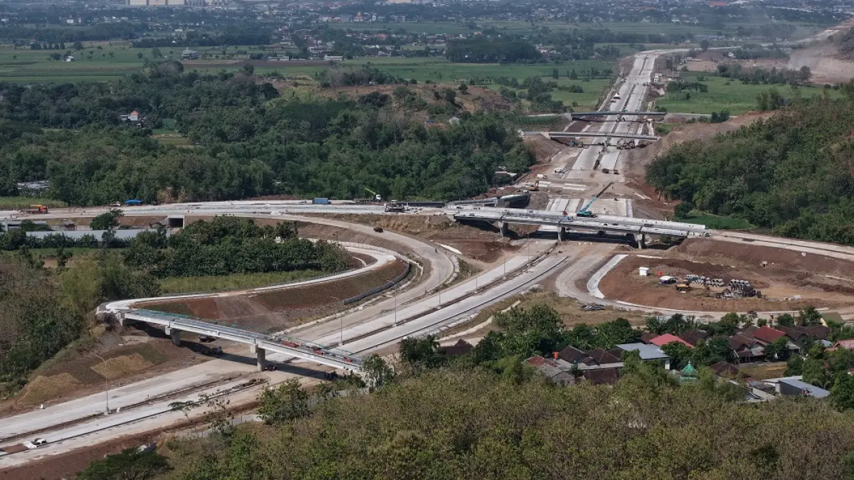 DIKEJAR DEADLINE: Pengerjaan proyek Tol Bandara di Simpang Empat Bulawen dikebut. Penyelesaian jalan bebas hambatan di ruas itu akan jadi penyokong operasional Embarkasi Dhoho tahun 2027 nanti. (Foto: Wahyu Adji)