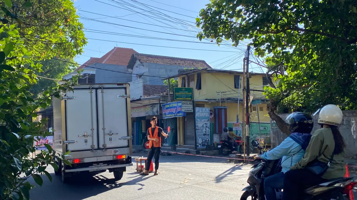 JALUR BARU : Salah seorang warga mengatur lalu lintas di depan Gang Labirin yang mendadak ramai karena jadi jalur alternatif setelah Jl Urip Sumoharjo ditutup. (HILDA NURMALA/JPRK)
