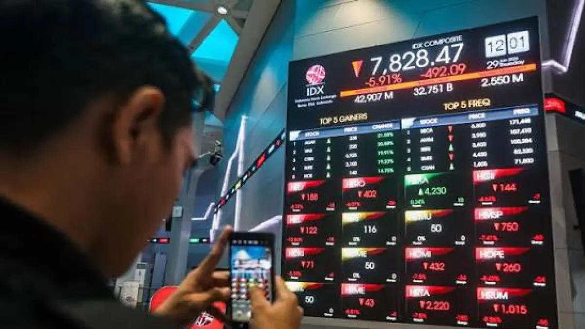 Seorang pria mengambil gambar layar pergerakan Indeks Harga Saham Gabungan (IHSG) yang sedang mengalami koreksi di Bursa Efek Indonesia.(Salman Toyibi/Jawa Pos)