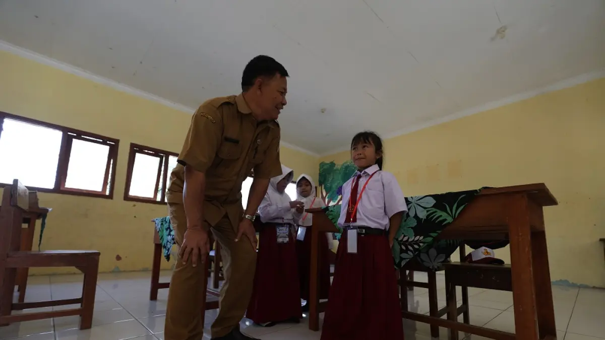 SATU-SATUNYA: Sukamto, guru SDN Bedug, Ngadiluwih berbincang dengan siswa baru yang mengikuti MPLS kemarin. Agar dia tidak merasa sendiri, sekolah melibatkan siswa kelas 2. (Foto: Wahyu Adji)
