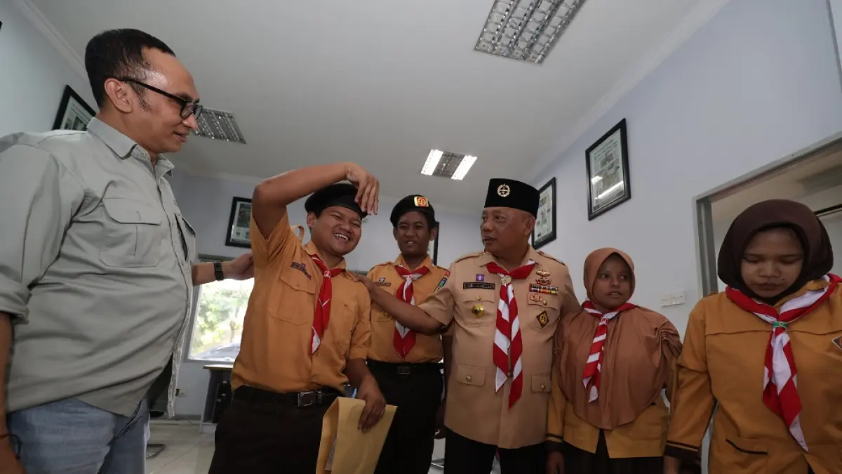 Ketua Kwartir Cabang (Kwarcab) Gerakan Pramuka Kota Kediri Edy Herwiyanto (tengah) dan Direktur Jawa Pos Radar Kediri Kurniawan Muhammad (kiri) berbincang dengan Pramuka Berkebutuhan Khusus (PBK) delegasi Jambore Nasional 2026. (Foto: Wahyu Adji)