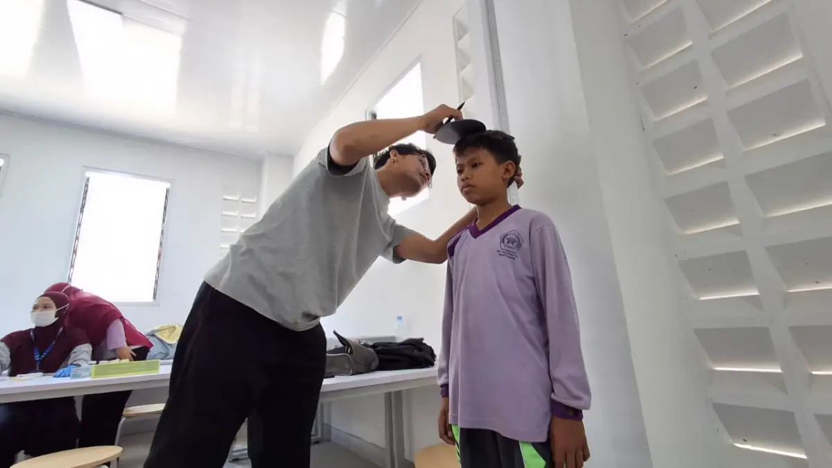 Petugas kesehatan sedang melakukan cek kesehatan pada siswa SR. (Foto Wahyu Adji)