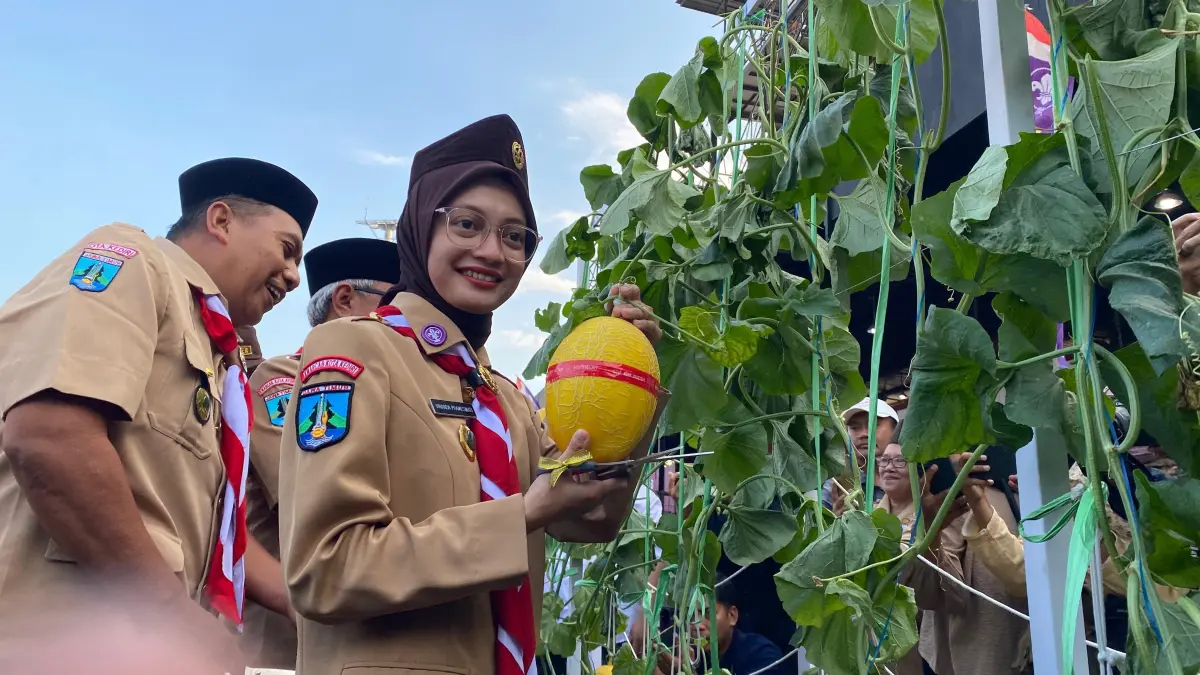 Wali Kota Kediri Vinanda memetik buah melon saat apel Pramuka di Stadion Brawijaya. (HILDA NURMALA RISANI)