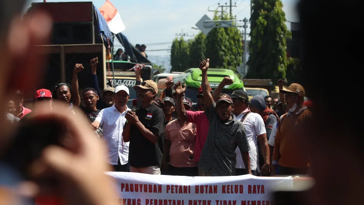 MENYOAL LAHAN PERHUTANI: Massa dari Paguyuban Petani Kelud Raya membawa sejumlah spanduk saat demo mempertahankan perjanjian kerja sama pengelolaan lahan hutan yang disoal oleh massa dari Serikat Pekerja Kebun SPSI Kediri. Foto kanan, polisi dan TNI memasang barikade untuk memisahkan massa dari Serikat Pekerja Kebun SPSI Kediri (baju biru). (Wahyu Adji/JPRK)