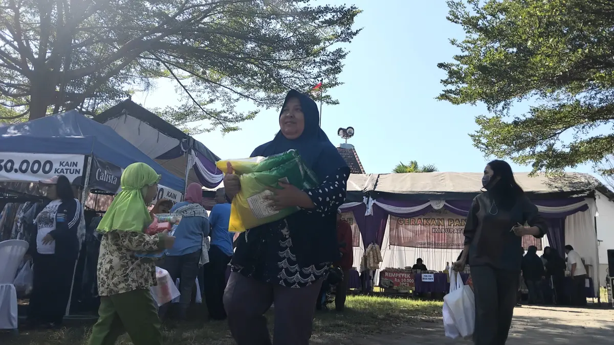 Warga membawa beras SPHP dari Gerakan Pasar Murah di Kantor Desa Menang (Diana Yunita/JPRK)