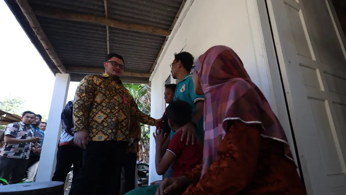 Bupati Hanindhito Himawan Pramana (baju batik) berbincang dengan Umi Khoiriyah, 63, dan keluarganya, di Desa Semanding, Pagu. Lansia yang rumahnya hampir ambruk itu juga mendapat bantuan kesehatan dan akses pendidikan. 