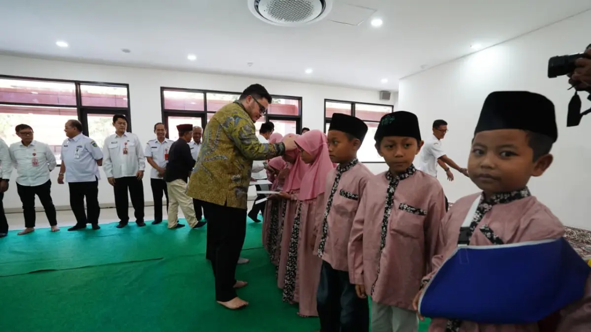 PENUH BERKAH: Mas Dhito menyerahkan santunan kepada sejumlah anak yatim yang ikut berdoa dalam tasyakuran penempatan gedung setda Pemkab Kediri. (Foto: Pemkab Kediri)