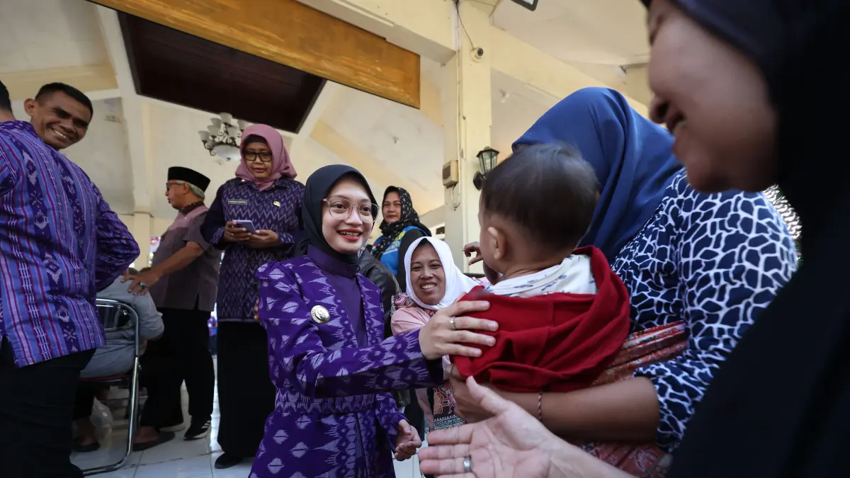 SAPA WARGA: Wali Kota Kediri Vinanda Prameswati menyapa anak-anak yang ikut orang tuanya mencairkan BLT DBHCHT di Pendapa Kecamatan Pesantren, kemarin. Total ada sekitar 4 ribu warga yang menerima bantuan secara bertahap. (Wahyu Adji/JPRK)