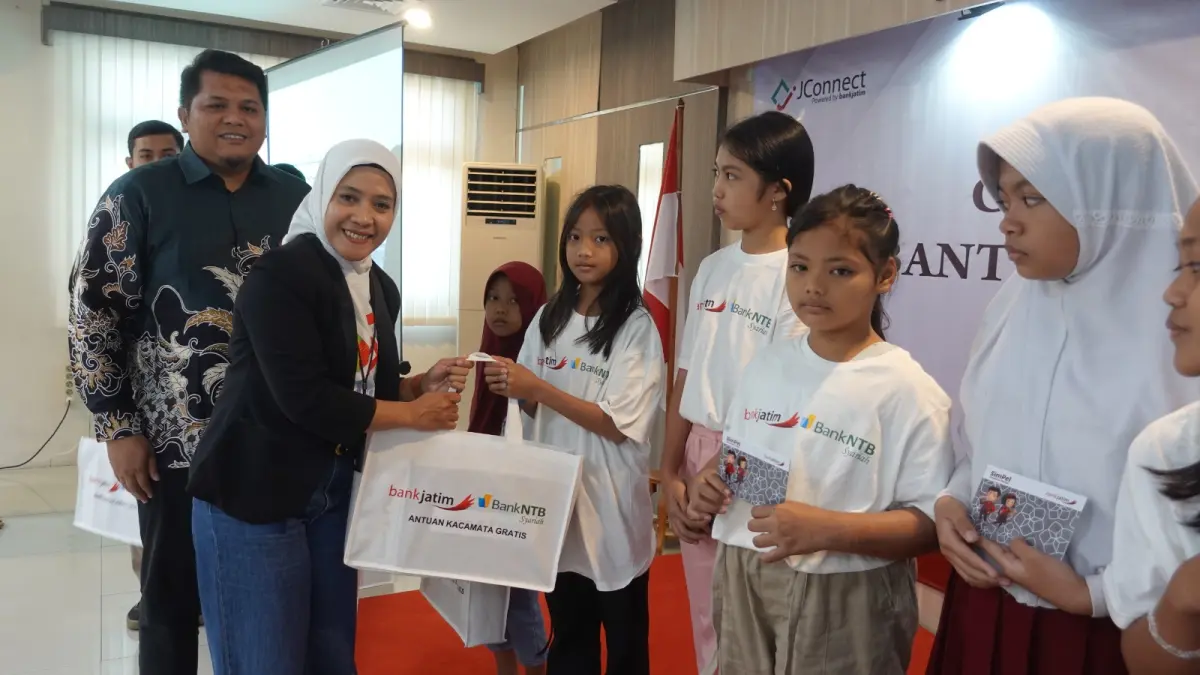 BERMANFAAT- Vice President Corporate Secretary Bank Jatim Fenty Rischana bersama Branch Manager Bank NTB Syariah Surabaya Ashrul Akbar menyerahkan kacamata gratis kepada anak pelajar. (Foto: Basid Alharis)