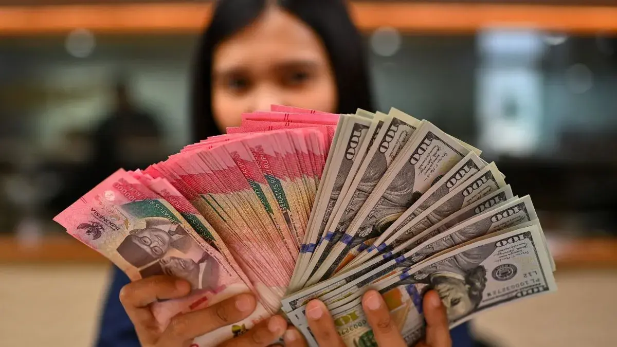 Karyawan memperlihatkan uang pecahan rupiah dan dolar Amerika Serikat (AS) di gerai penukaran mata uang asing Ayu Masagung, Jakarta, Selasa (12/5/2026). ANTARA FOTO/Indrianto Eko Suwarso/kye