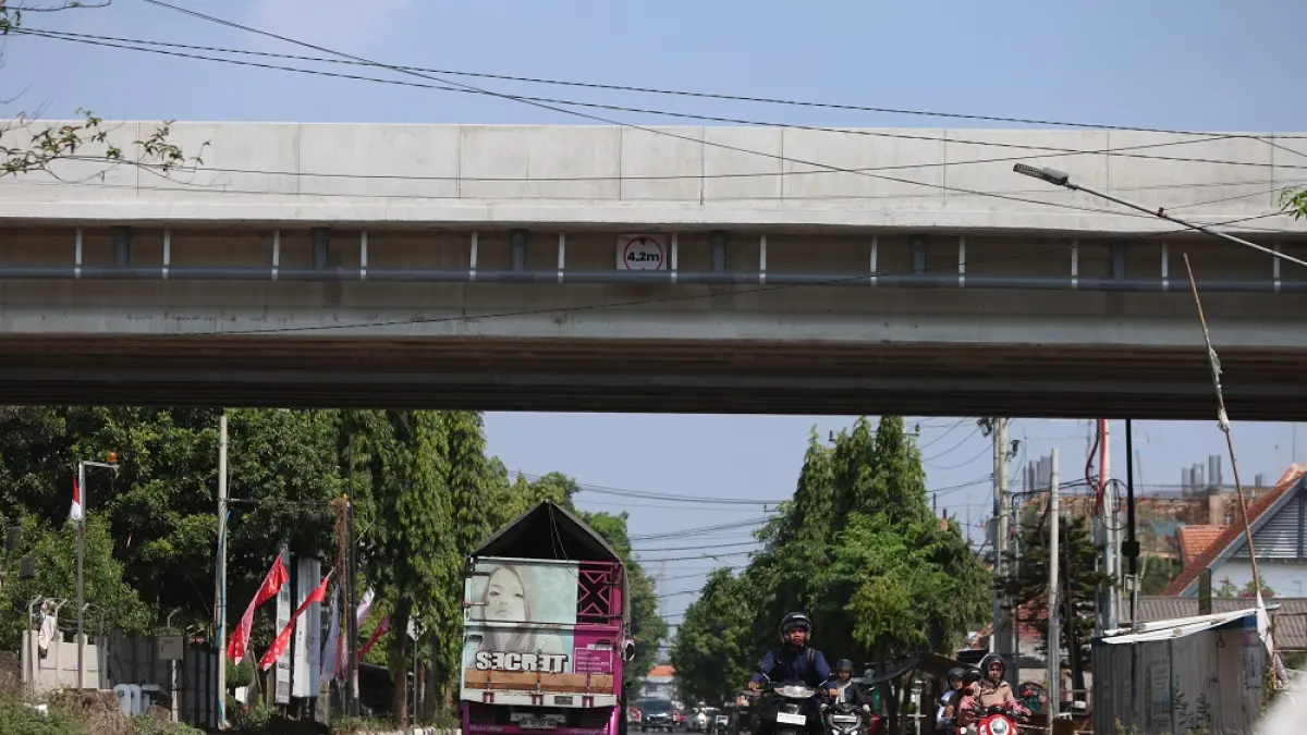 TERUS DIKEBUT: Warga melintas di underpass tol Jl Jaksa Agung Suprapto, Kelurahan Mojoroto, Kota Kediri. Hingga awal Agustus ini, pembebasan tanah aset pemkot yang terdampak tol akses bandara masih belum menemui titik temu. (Foto: Wahyu Adji)
