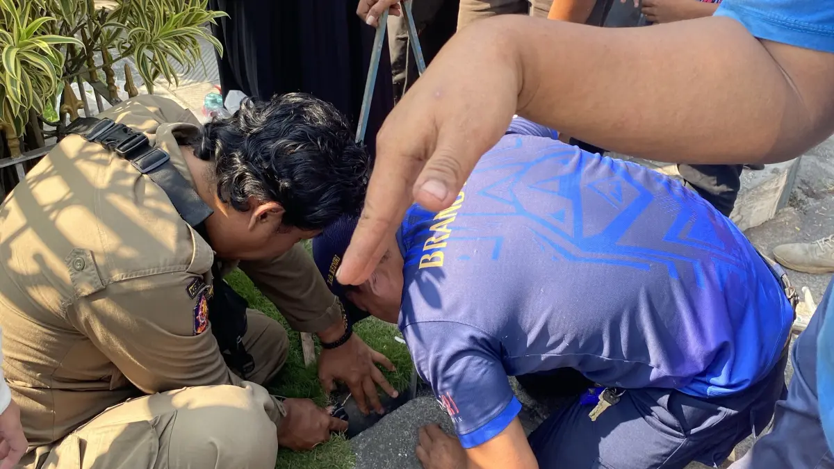 Petugas damkar saat berjibaku mengevakuasi HP yang terjebur di selokan. (Foto Damkar Kabupaten Kediri)