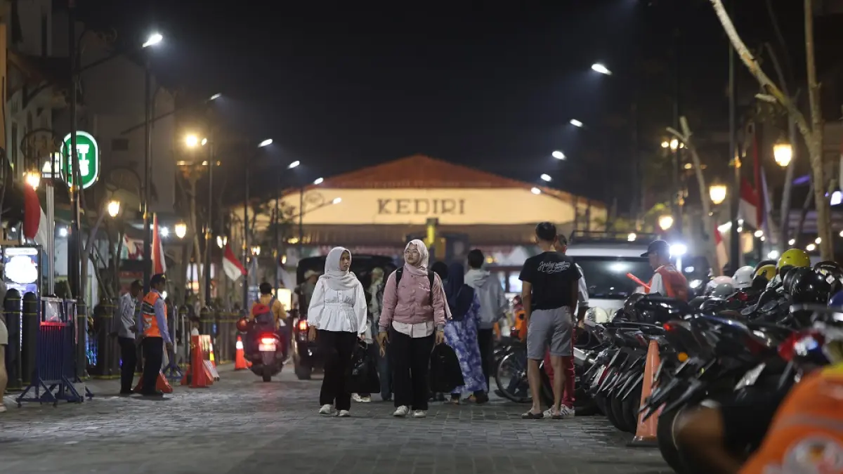 Pejalan kaki berjalan di tengah ruas Jalan Stasiun di malam hari. (Foto: Wahyu Adji)