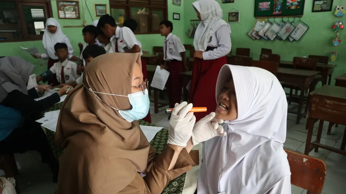 CEK KESEHATAN: Salah seorang nakes memeriksa kondisi gigi siswa SDN Blabak 1 Kota Kediri. (Foto: Ayu Isma)