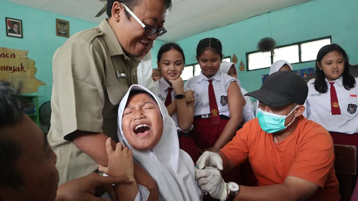 KESAKITAN: Salah seorang pelajar SDN Campurejo 2 berteriak saat disuntik vaksin HPV oleh petugas kesehatan. (Foto: Ayu Isma)