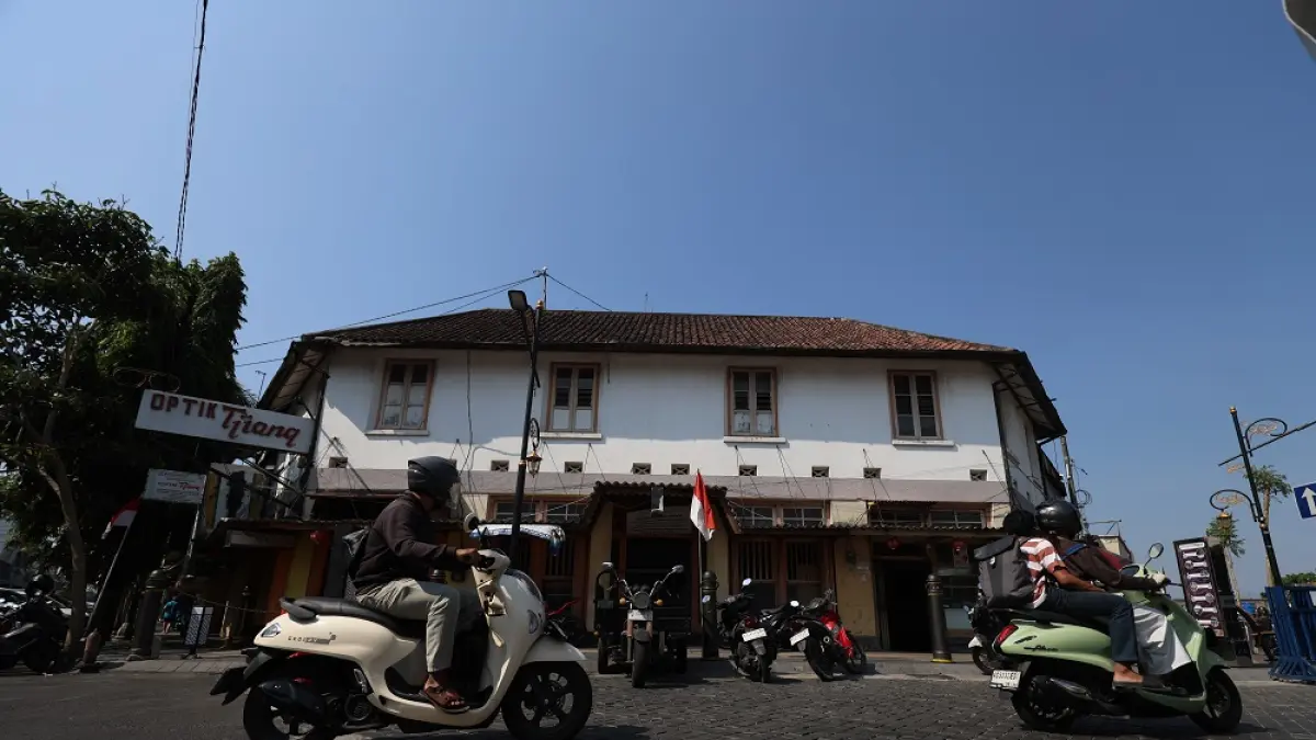 Pengendara motor melintas di depan bangunan tua di persimpangan Jalan Stasiun dan Jalan Dhoho, Kota Kediri. (Foto: Wahyu Adji)