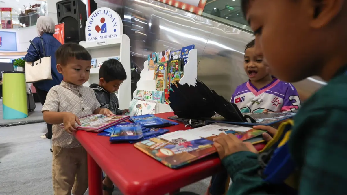 SARANA EDUKASI: Pengunjung anak-anak pun enjoy membaca buku di booth area QRISNIVAL di atrium Kediri Town Square saat orang tua mereka asyik berbelanja di stan UMKM.