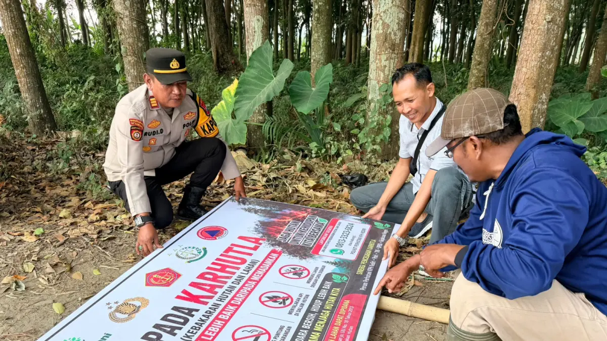 Kapolsek Kepung saat memasang imbauan mencegah kebakaran. (Foto Polsek Kepung)
