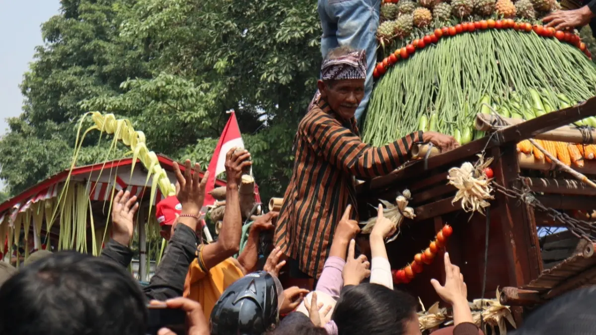 BERGEROMBOL: Warga yang menonton Parade Cikar berusaha mendapatkan aneka sayur yang dibagikan oleh salah seorang parade yang berlangsung di SLG Kediri. (FOTO: Emilia/JPRK)
