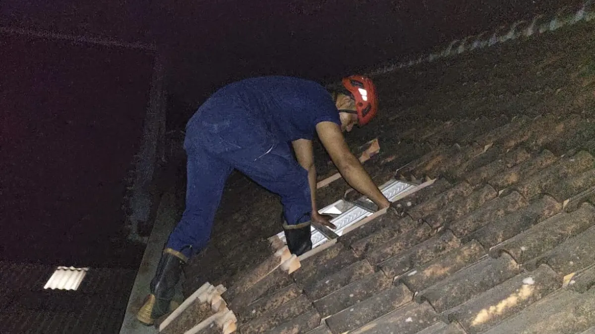 Petugas damkar harus masuk lewat genteng untuk bisa membuka pintu yang terkunci dari dalam. (Foto Damkar Kabupaten Kediri)