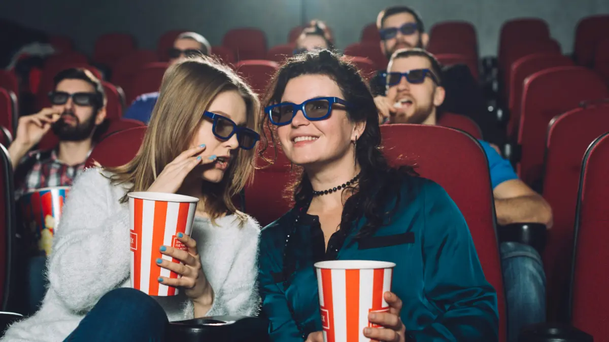 Ilustrasi penonton yang berbincang saat menikmati film di bioskop. Membagikan bagian penting dari jalan cerita dapat menjadi spoiler bagi orang yang belum menontonnya. Foto: magnific