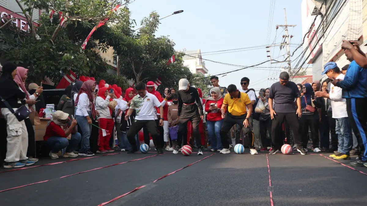 (Dari kiri) Dandim 0809 Letkol Inf Dhavid Nur Hadiansyah, Wali Kota Vinanda Prameswati, Kapolres Kediri Kota AKBP Kresno Wisnu Putranto, dan Wawali Qowimuddin mengikuti permainan menggiring bola menggunakan terong dalam Agustusan di CFD Jalan Dhoho, Minggu (30/8). (Foto: Ayu Isma)