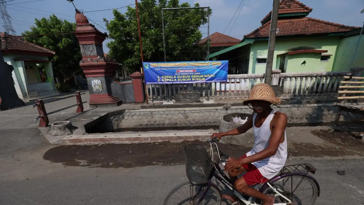Seorang warga melintas di depan Kantor Desa Nanggungan, Kayenkidul. Desa mulai membuka rekrutmen untuk mengisi kekosongan jabatan. (Foto: Wahyu Adji)