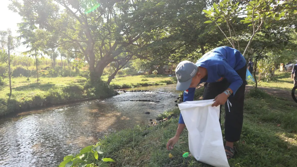 Salah satu pelajar peserta cleanup saat mengumpulkan sampah yang berserakan di kawasan wisata Kali Bening Ngancar. (Foto: Ayu Isma)