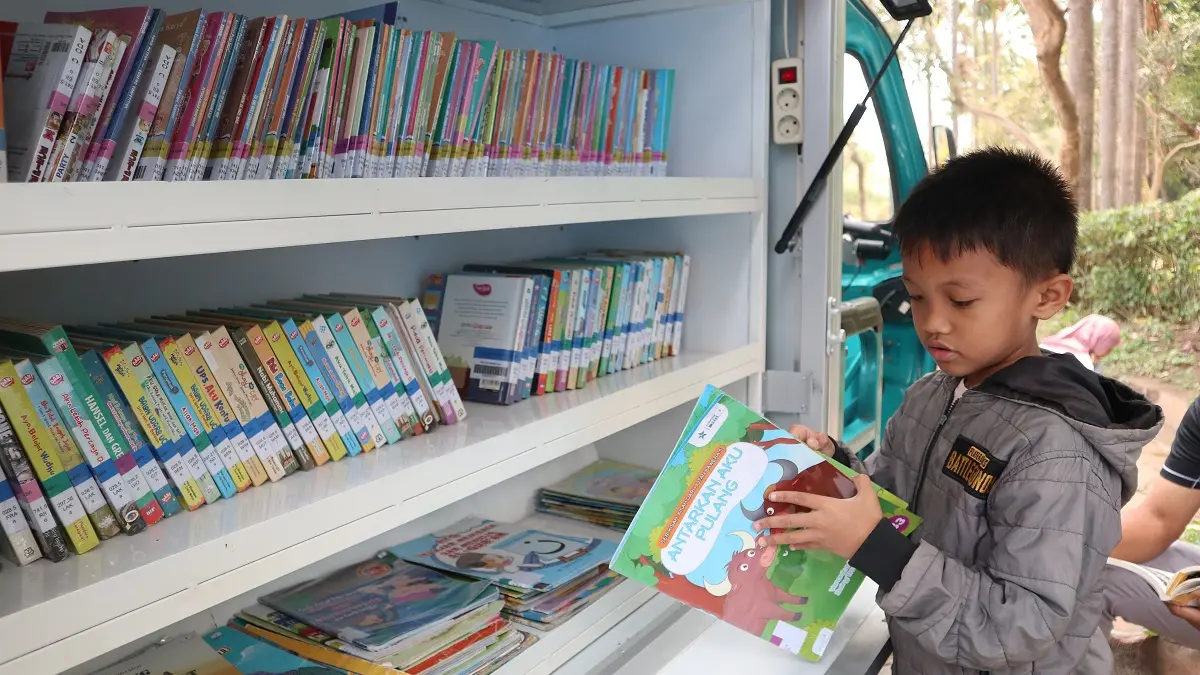 Anak-anak ikut mengakses buku yang dibawa perpustakaan keliling di Taman Brantas Kota Kediri. (Foto: Ayu Isma)