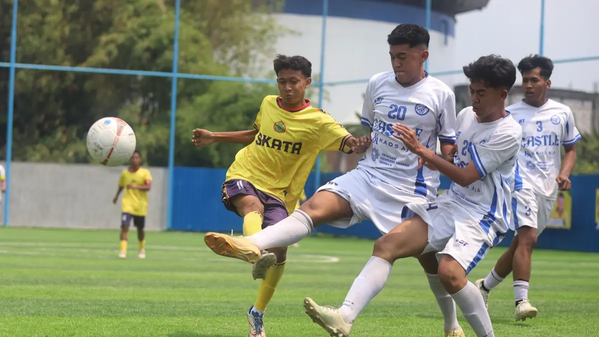 LAGA PERDANA: Dua penggawa SMAN 1 Puri (kostum putih) berusaha merebut bola dari pemain Tamansiswa Mojokerto di laga babak 16 besar. Pertandingan tersebut dimenangkan tim Tamansiswa Mojokerto lewat adu penalti dengan skor 3-2. (SOFAN KURNIAWAN/RADAR MOJOKERTO)