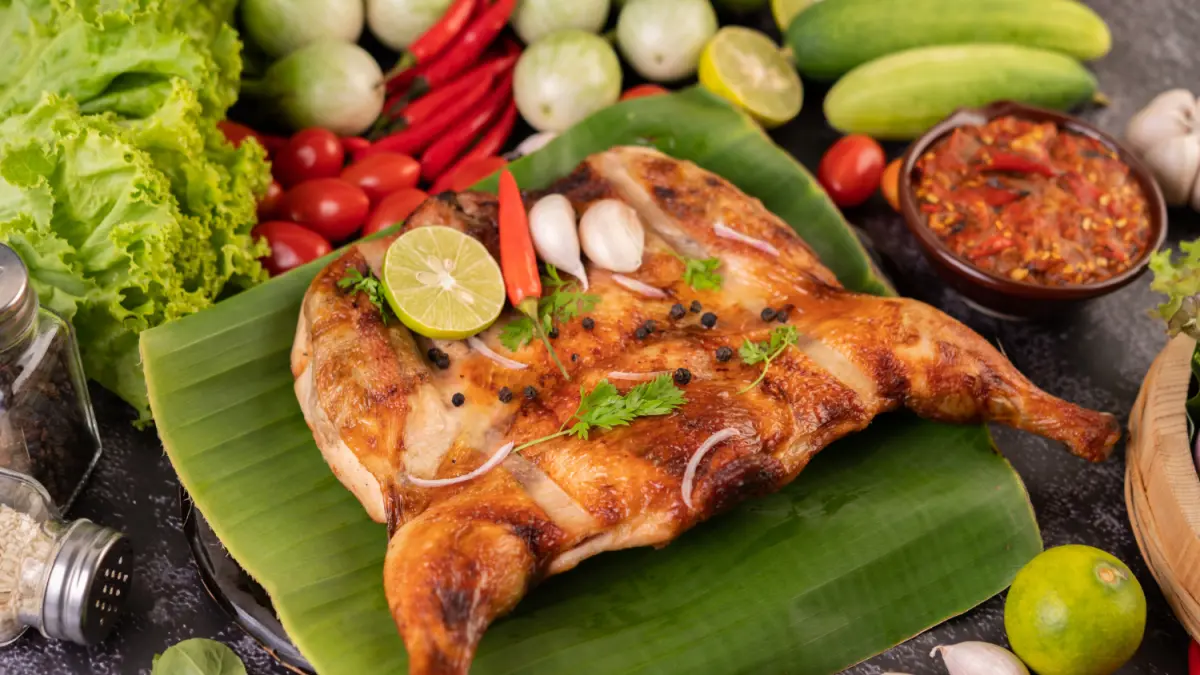 Ilustrasi ayam bakar dengan sambal dan lalapan sebagai salah satu pilihan kuliner berbahan ayam. (Freepik)