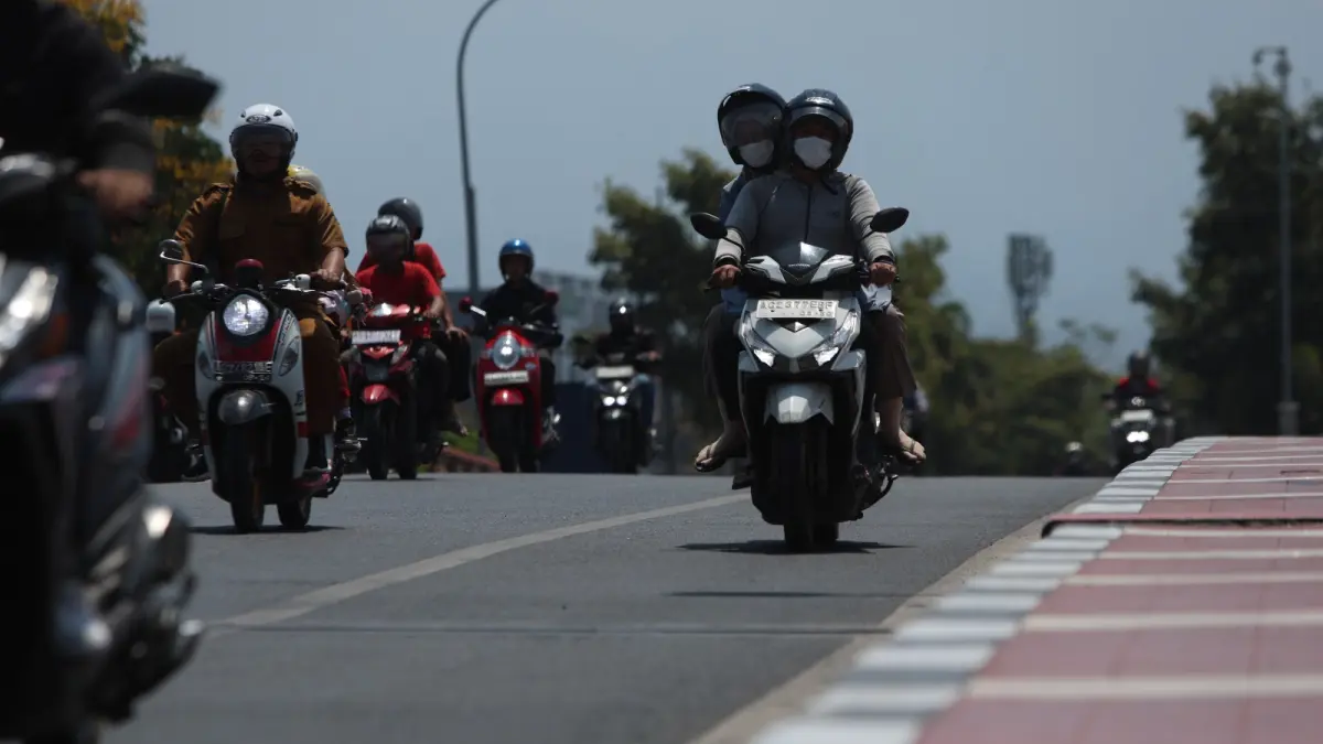 Ilustrasi pengendara motor di Kota Kediri mengenakan masker saat berkendara di jalan imbas cuaca panas dan kering. (Foto: Wahyu Adji)