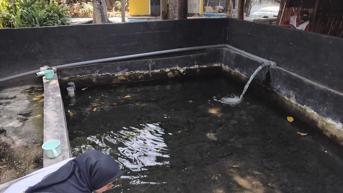 Pengunjung Sendang Jogotowo bermain air dari salah satu sumber air. (Foto: Diana Yunita)