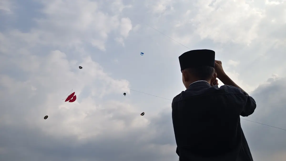 Seorang warga sedang menerbangkan layang-layang. (Foto Asad MS)