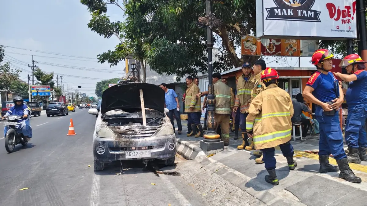 Satu unit mobil yang terbakar di Jl Soekarno Hatta Kabupaten Kediri usai berhasil dipadamkan petugas pemadam kebakaran. (Foto: Asad MS)