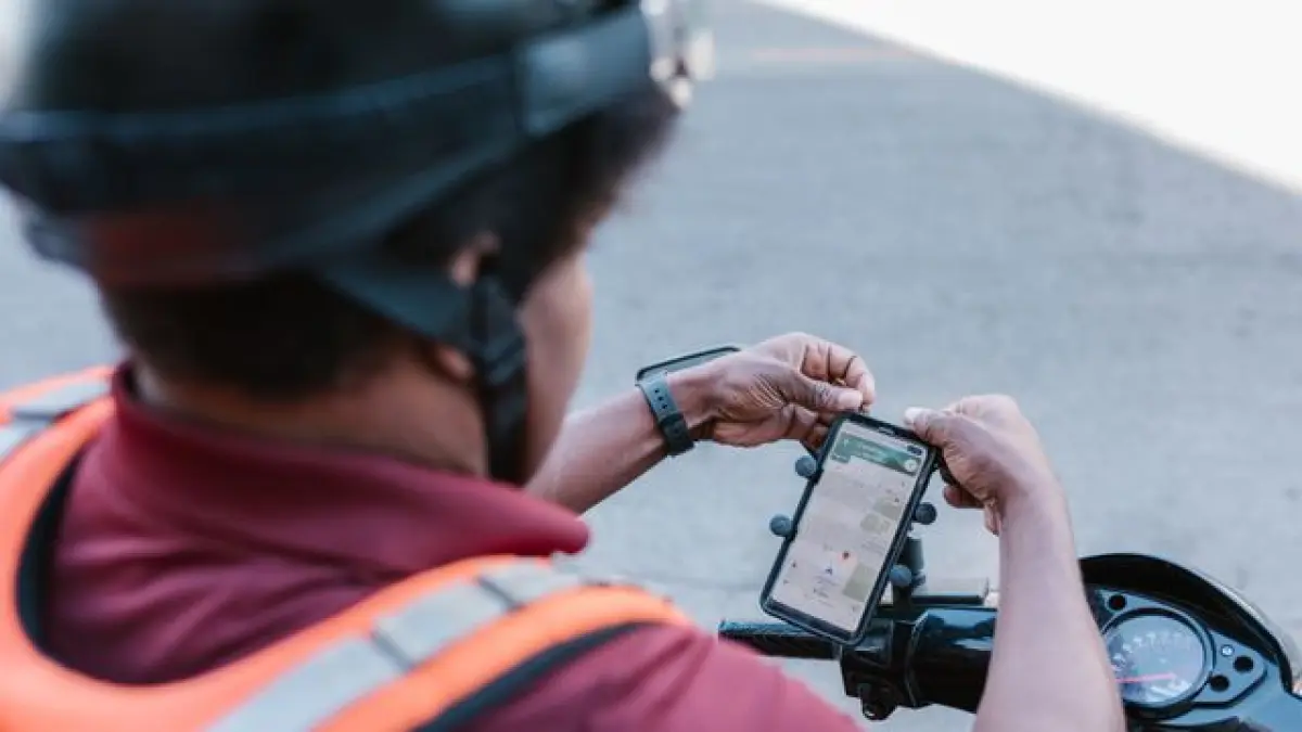 Ilustrasi pengendara motor menggunakan map dari ponselnya (pexels)