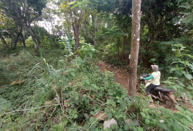 LOKASI SOLUSI: Pengendara sepeda motor melewati lokasi proyek tempat pembuangan akhir (TPA) regional di Desa Surat, Kecamatan Mojo. (Rekian/JPRK)