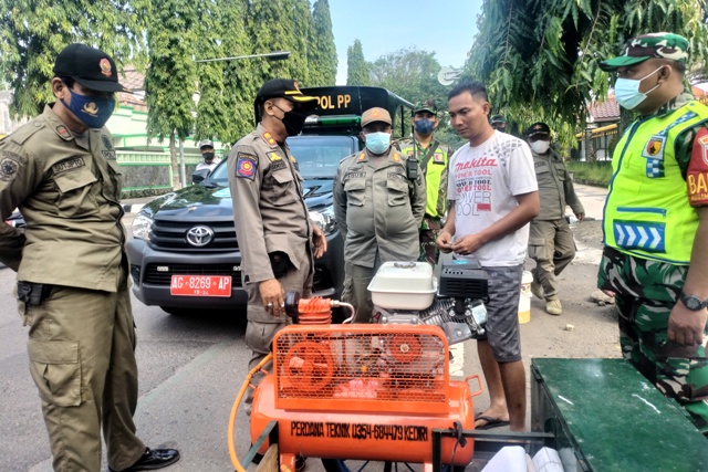 BERI PERINGATAN: Satpol pp dan TNI mendatangi PKL yang berjualan melewati jam operasional pagi. Jika membandel, aparat penegak perda akan mengangkut lapaknya. (Foto: Ilmidza Amalia Nadzira)