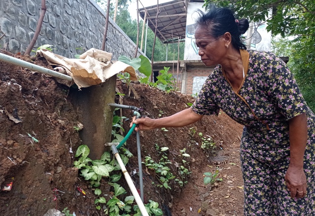 KERING: Warga Dusun Besuki, Desa Jugo, Kecamatan Mojo Sukati membuka kran yang airnya sudah tidak mengalir kemarin (24/6). (Rekian/JPRK)