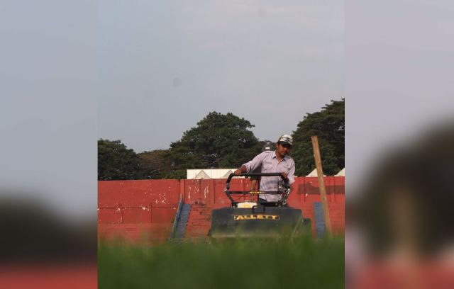 BELUM SELESAI: Petugas dari PT Harapan Jaya Lestarindo saat sedang meratakan rumput di Stadion Brawijaya. (Iqbal Syahroni/JPRK)