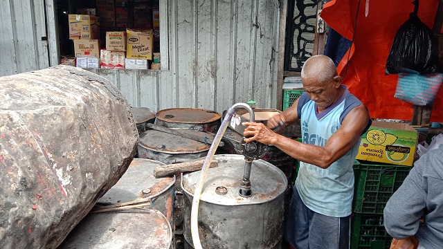 TERSEDIA: Pedagang menyedot minyak goreng curah dari drum. (Foto: Ilmidza Amalia Nadzira)