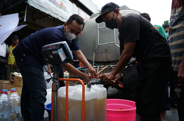 BAHAN KEBUTUHAN POKOK: Petugas mendistribusikan minyak goreng curah kepada masyarakat dari tangki truk di Pasar Pamenang, Kelurahan/Kecamatan Pare beberapa waktu yang lalu. Kini pembelian komoditas tersebut harus disertai dengan syarat. (Wahyu Adji/JPRK)